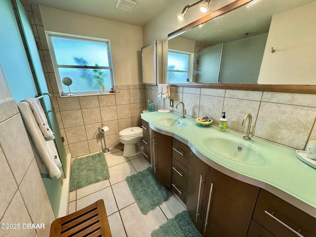 153 University Cir, Ormond Beach, FL 32176 - bathroom featuring tile walls, double vanity, tile patterned floors, plenty of natural light, and a shower