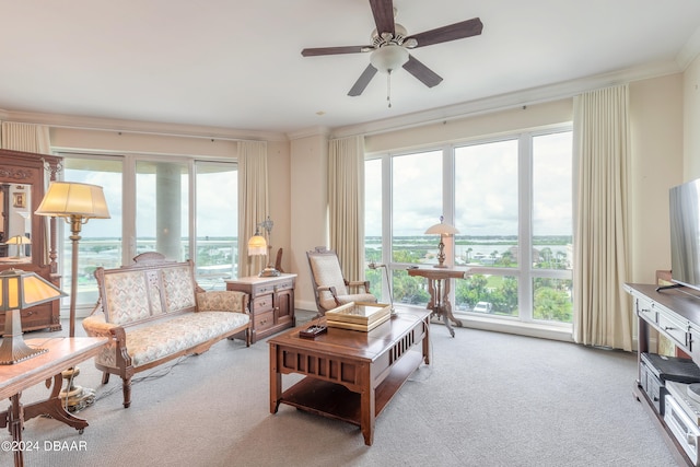 interior space featuring ornamental molding, light colored carpet, and ceiling fan