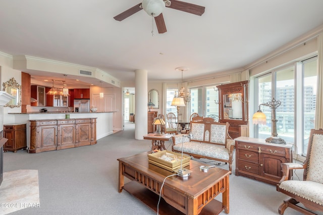 carpeted living room with ceiling fan with notable chandelier and ornamental molding