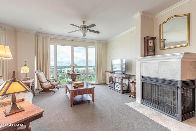 carpeted living room with a tile fireplace, ceiling fan, and ornamental molding