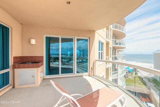 balcony featuring a beach view and a water view