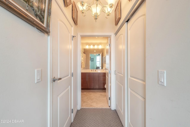 hall featuring a notable chandelier and light tile patterned flooring