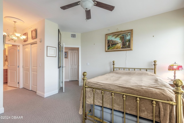 bedroom with ceiling fan with notable chandelier and carpet