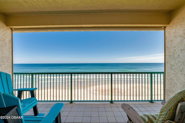 balcony featuring a water view and a view of the beach