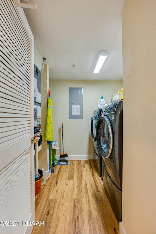 washroom featuring washer and clothes dryer, electric panel, and hardwood / wood-style floors