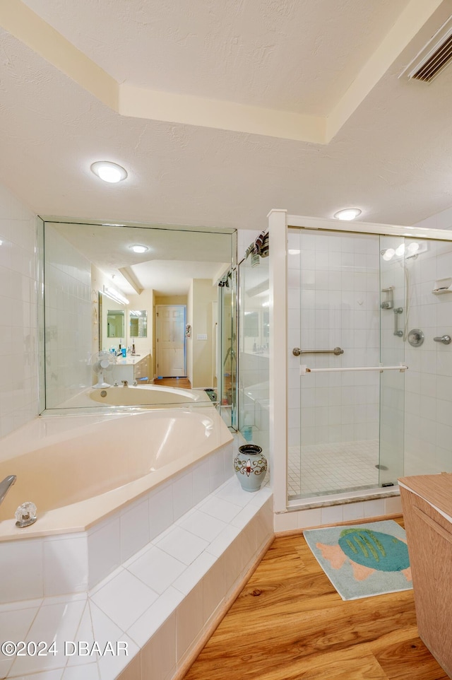 bathroom with hardwood / wood-style flooring and separate shower and tub