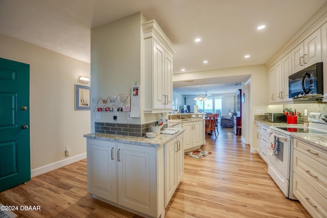 kitchen featuring electric range, light stone counters, light hardwood / wood-style flooring, kitchen peninsula, and white cabinets