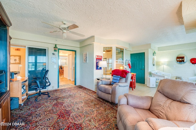 living room featuring ceiling fan, a textured ceiling, and light wood-type flooring