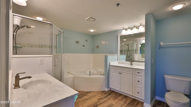 full bathroom featuring toilet, separate shower and tub, hardwood / wood-style floors, a textured ceiling, and vanity