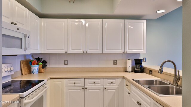 kitchen featuring white cabinetry, tasteful backsplash, sink, and white appliances