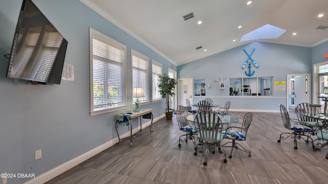 dining room with lofted ceiling with skylight and ornamental molding