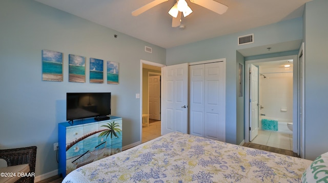 tiled bedroom featuring a closet, ceiling fan, and ensuite bath