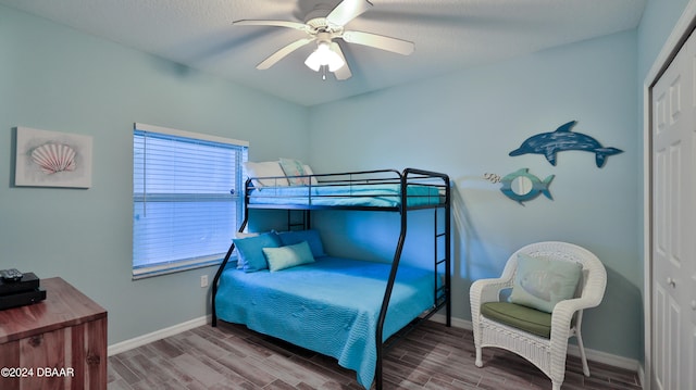 bedroom featuring hardwood / wood-style floors, ceiling fan, and a closet