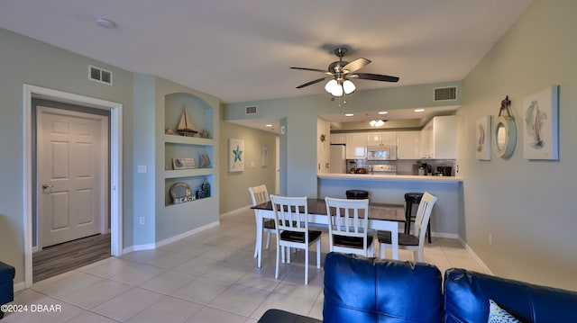 dining space with built in shelves, ceiling fan, and light tile patterned floors