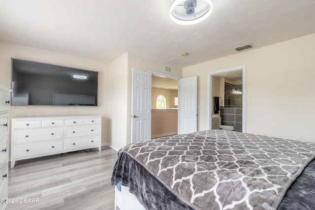 bedroom with light hardwood / wood-style floors and ensuite bath