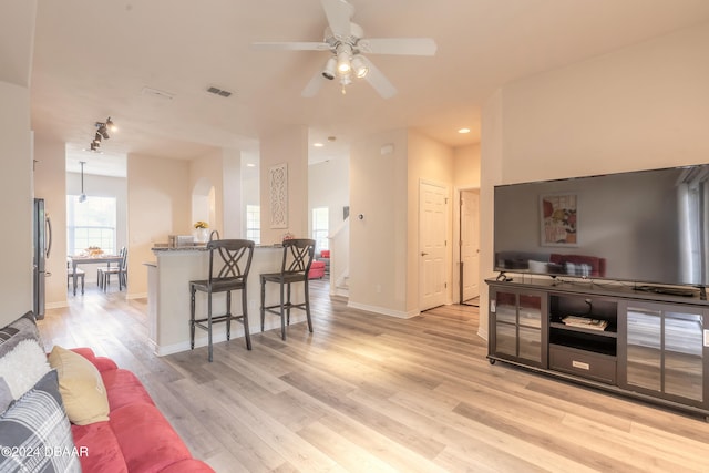 living room featuring light wood-type flooring and ceiling fan