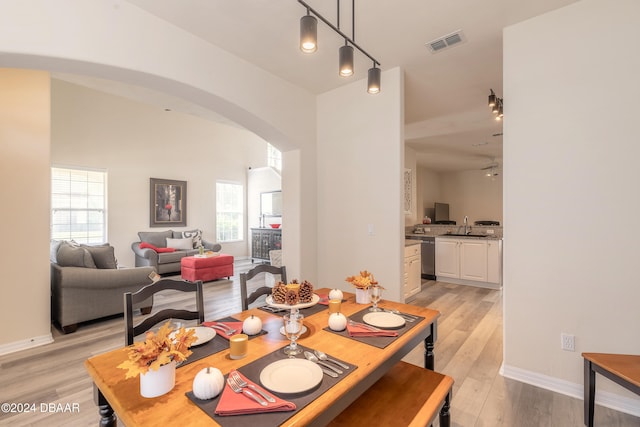 dining space featuring ceiling fan, sink, and light hardwood / wood-style flooring