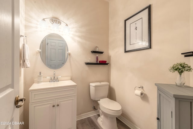 bathroom featuring toilet, vanity, and hardwood / wood-style flooring