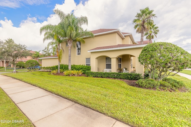 mediterranean / spanish-style house with a front yard