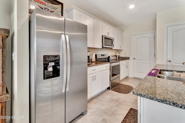 kitchen featuring white cabinets, dark stone countertops, and stainless steel appliances