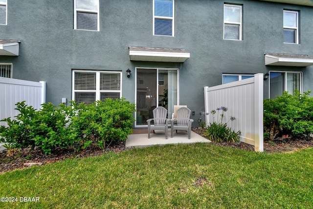 rear view of house featuring a lawn and a patio area