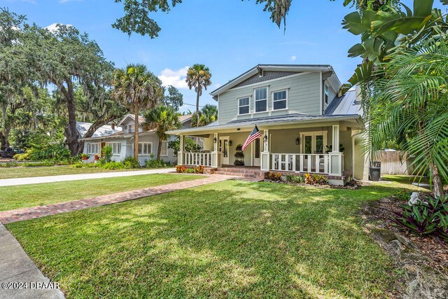 509 Faulkner St, New Smyrna Beach, FL 32168 - view of front of house featuring a porch and a front lawn