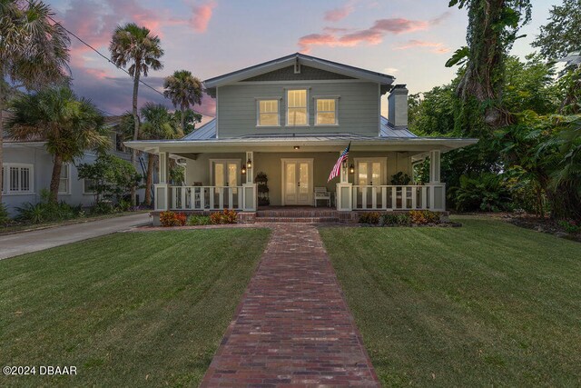 509 Faulkner St, New Smyrna Beach, FL 32168 - farmhouse featuring covered porch and a lawn