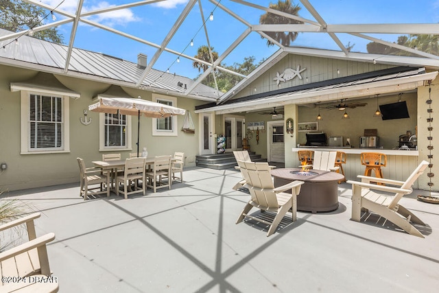 509 Faulkner St, New Smyrna Beach, FL 32168 - view of patio / terrace with exterior bar, an outdoor fire pit, glass enclosure, and ceiling fan