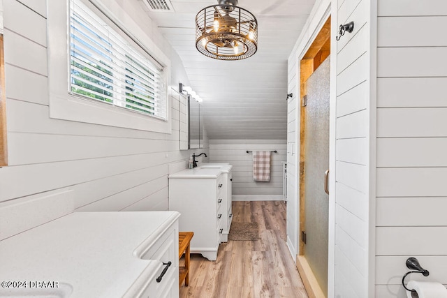 509 Faulkner St, New Smyrna Beach, FL 32168 - bathroom with vaulted ceiling, hardwood / wood-style floors, wood walls, vanity, and walk in shower