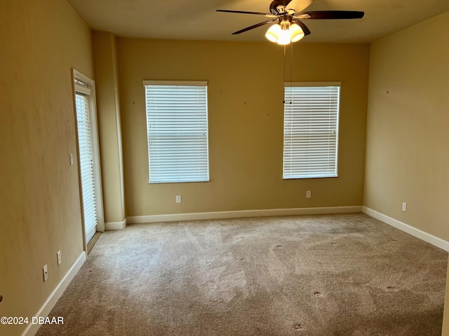 carpeted spare room with ceiling fan