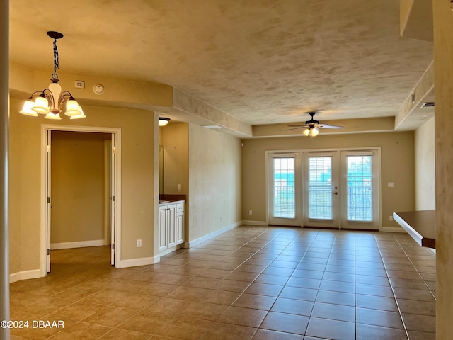 spare room with ceiling fan with notable chandelier and light tile patterned floors