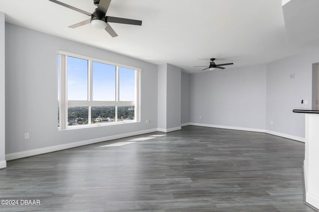 unfurnished living room featuring dark wood-type flooring and ceiling fan