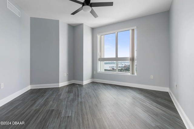 spare room with dark hardwood / wood-style flooring and ceiling fan