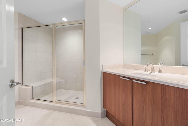 bathroom with walk in shower, vanity, and tile patterned floors