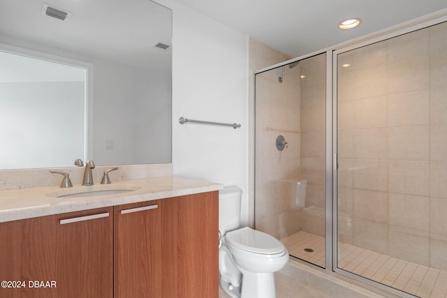 bathroom featuring walk in shower, vanity, tile patterned floors, and toilet