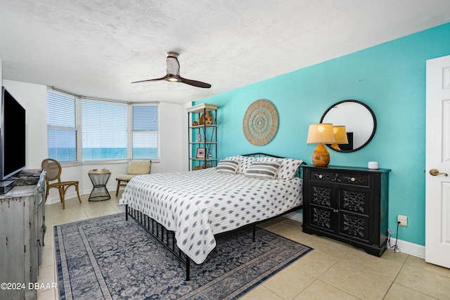 tiled bedroom with a textured ceiling and ceiling fan