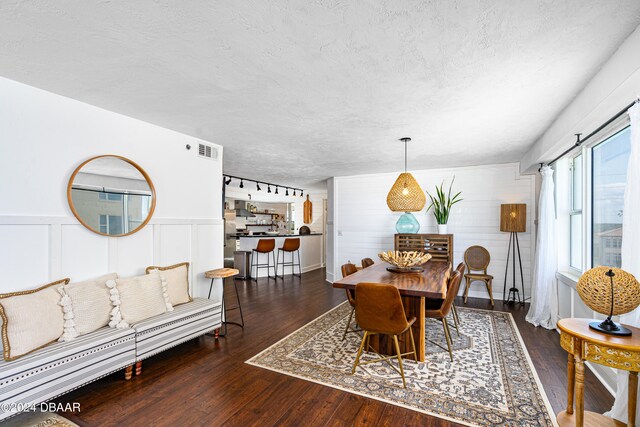 dining area featuring a textured ceiling and dark hardwood / wood-style flooring