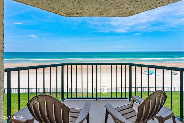 balcony featuring a beach view and a water view