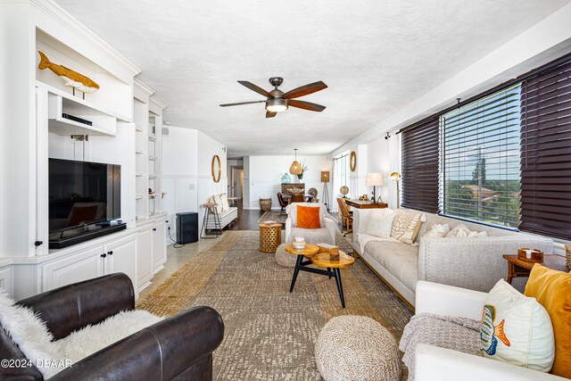 living room with a textured ceiling and ceiling fan