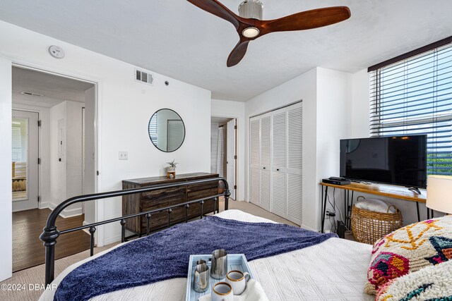 bedroom with a closet, light wood-type flooring, and ceiling fan