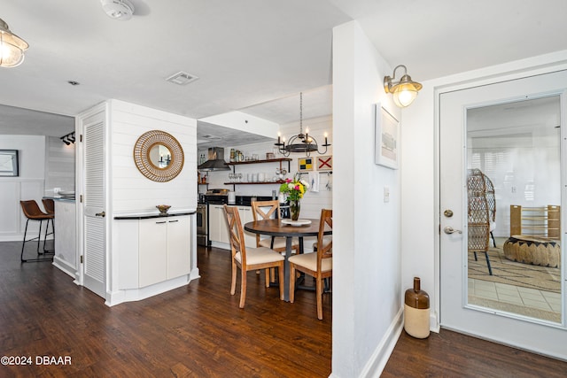 dining area with dark wood-type flooring and a chandelier