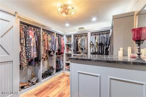 walk in closet with light hardwood / wood-style flooring