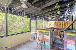 sunroom / solarium featuring ceiling fan