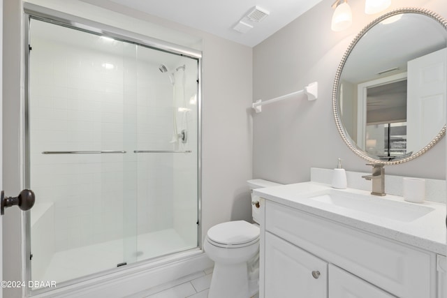 bathroom featuring tile patterned flooring, an enclosed shower, vanity, and toilet