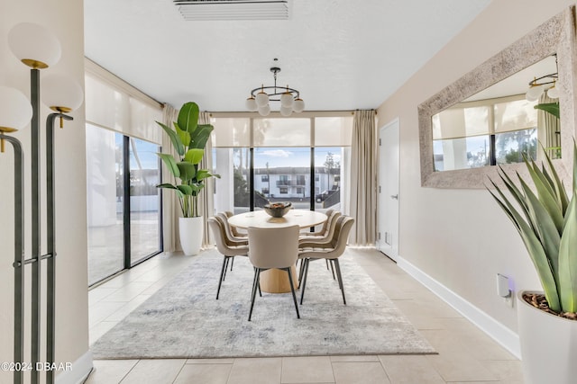 tiled dining room featuring an inviting chandelier