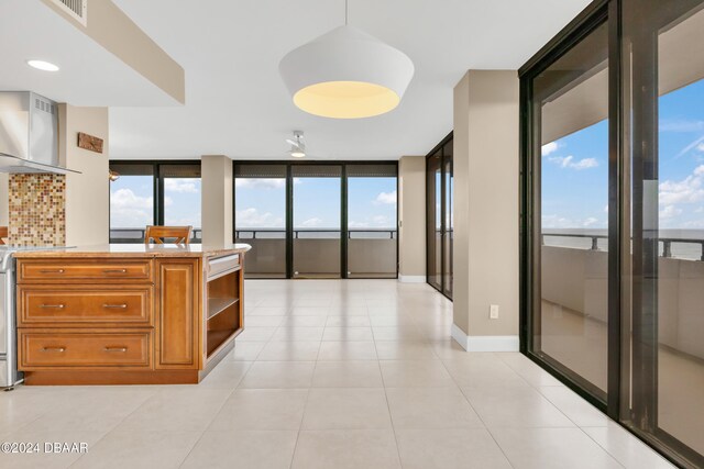 corridor featuring light tile patterned flooring and a wall of windows