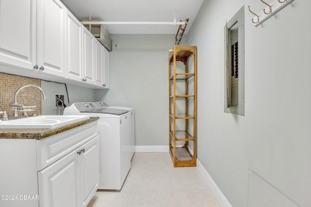 laundry area with cabinets, washing machine and dryer, light tile patterned floors, and sink