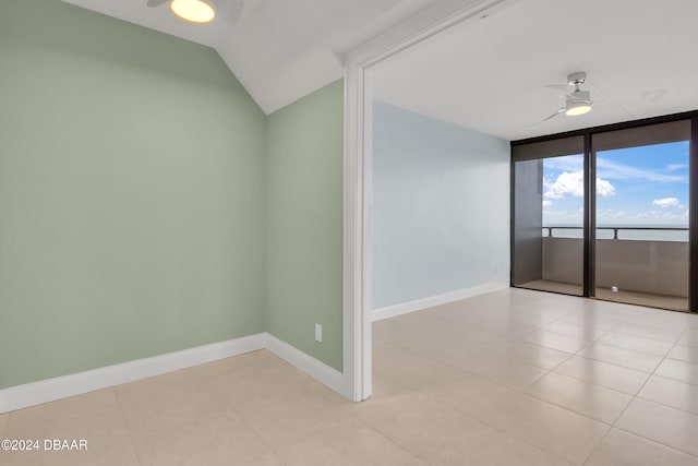 spare room with expansive windows, ceiling fan, and light tile patterned floors