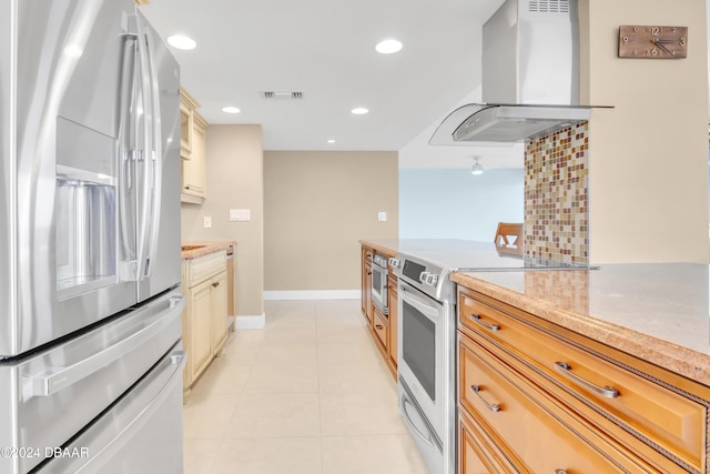 kitchen with wall chimney exhaust hood, light tile patterned floors, decorative backsplash, and appliances with stainless steel finishes