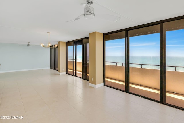 2200 N Atlantic Ave Unit 1602, Daytona Beach, FL 32118 - unfurnished room featuring baseboards, floor to ceiling windows, a water view, and ceiling fan with notable chandelier